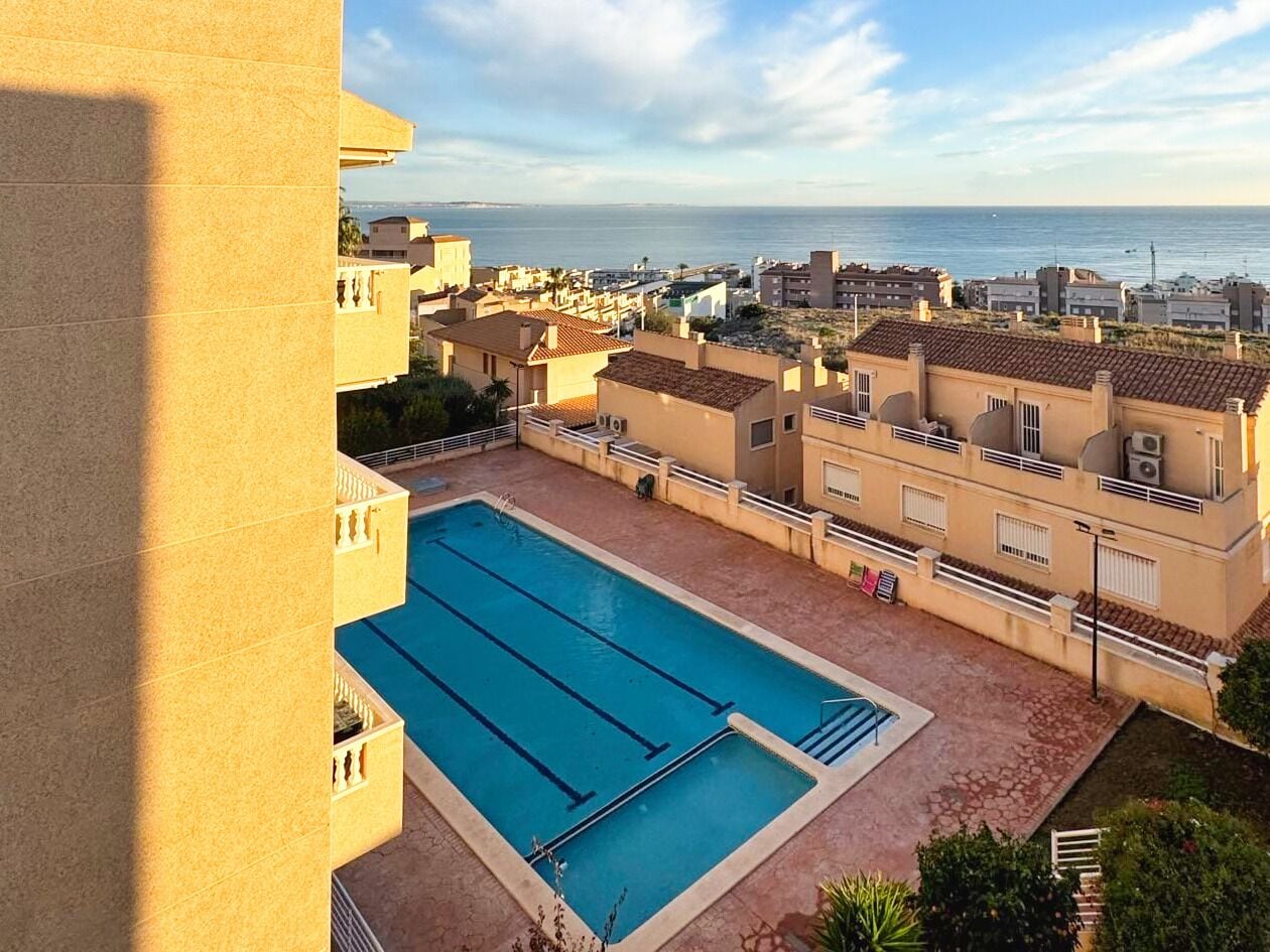 Une piscine offrant une vue dégagée sur la mer et les bâtiments en arrière-plan.