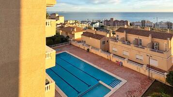 Une piscine offrant une vue dégagée sur la mer et les bâtiments en arrière-plan.