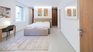 A modern bedroom with a bed, desk, chair, and artwork on the walls. - Lussuosa residenza nel centro di Verona (Verona)
