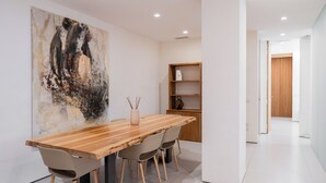 A modern dining area with a wooden table, four chairs, a vase, and a large abstract painting on the wall. - Lussuosa residenza nel centro di Verona (Verona)