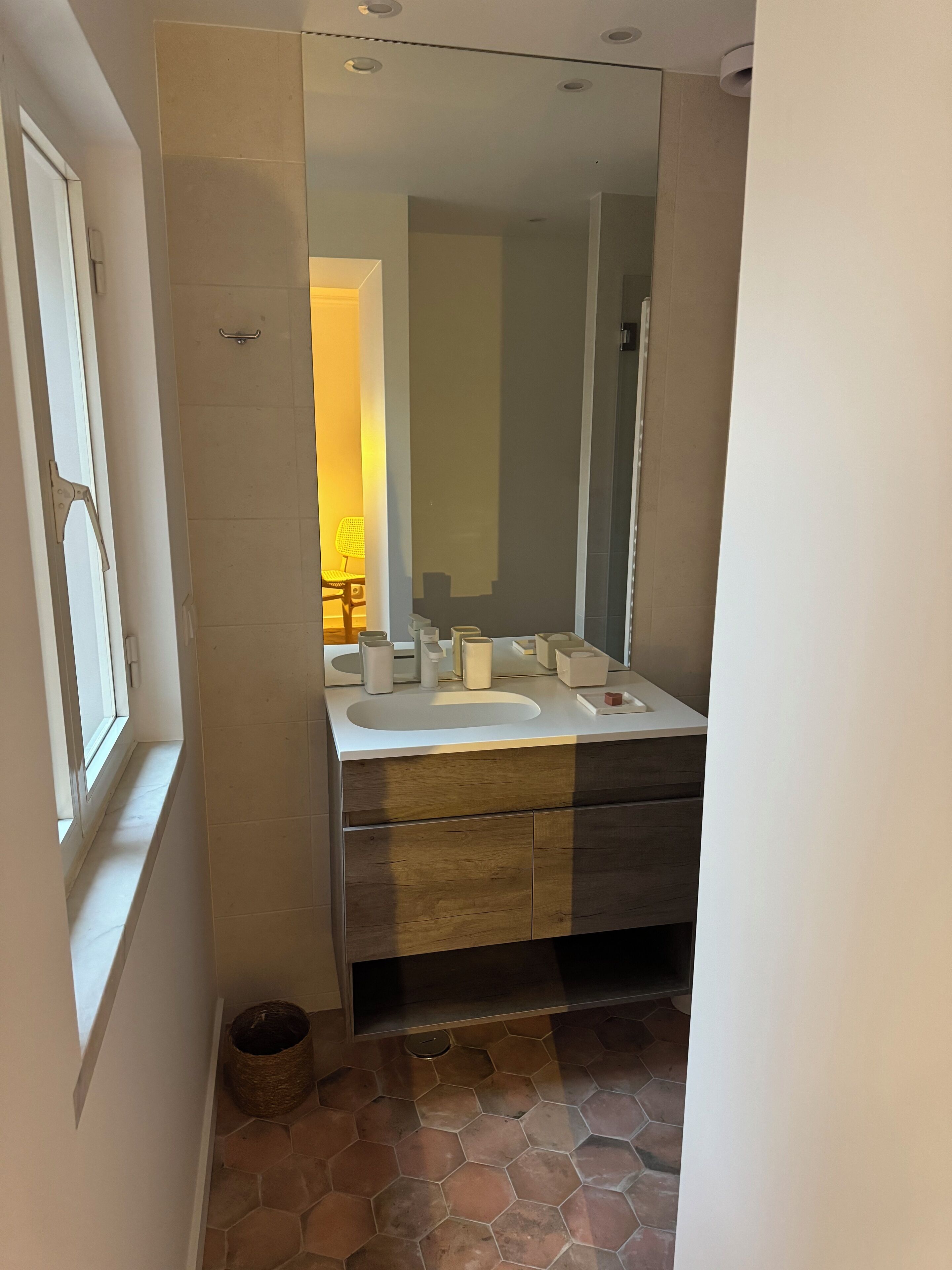 Une salle de bain avec un grand miroir, deux lavabos et une douche.