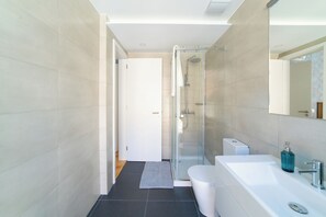 Luxe appartement | Badkamer | Een douche, een haardroger, handdoeken, zeep