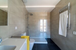 Luxe maisonnette | Badkamer | Een douche, een haardroger, handdoeken, zeep