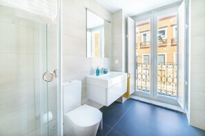 Luxe appartement | Badkamer | Een douche, een haardroger, handdoeken, zeep