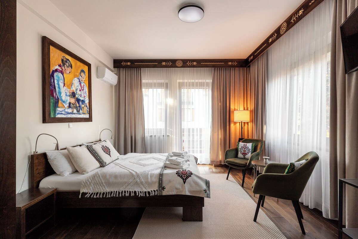 Una habitación de hotel con una cama, una silla, una lámpara y un cuadro en la pared.