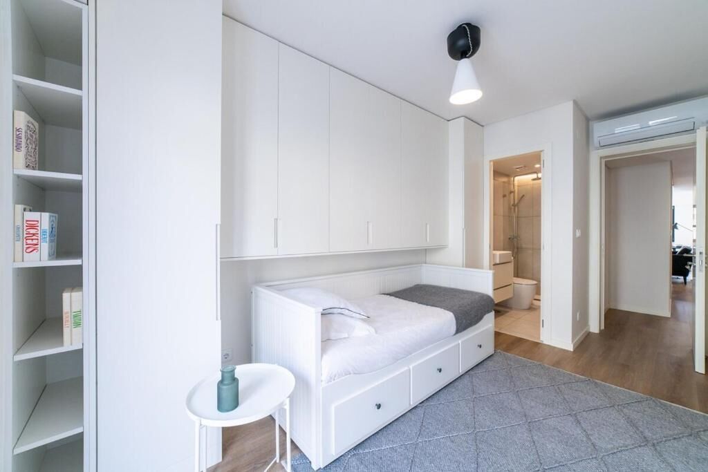Une chambre à coucher avec un lit, une petite table et une armoire.