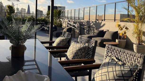A rooftop terrace with outdoor seating, a bar area, and potted plants. - Flat Cabo Branco Aurea 50m do mar 602 (João Pessoa)