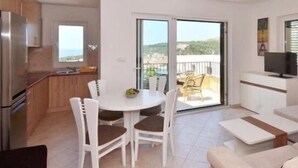 A modern apartment with a kitchen, dining area, and a balcony with a view. - royale 3 with shared pool Hvar (Hvar)