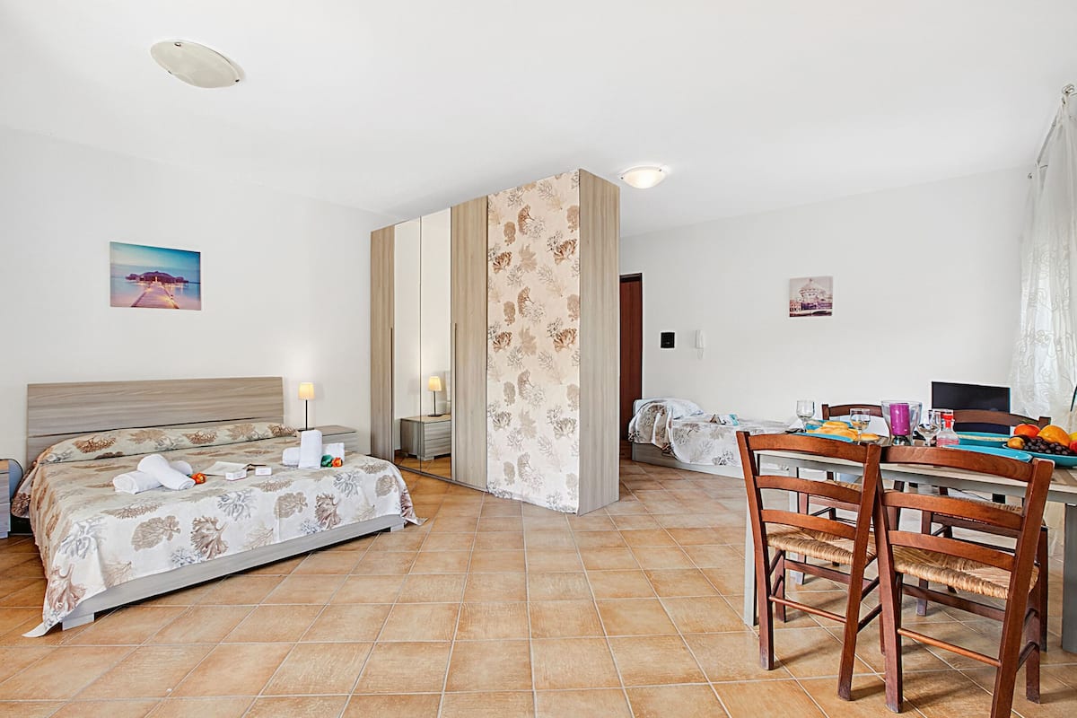 A hotel room with a bed, a desk, and chairs.