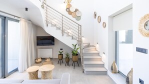 Ein modernes Interieur mit Treppe, einer Sitzecke und Wandkunst.
