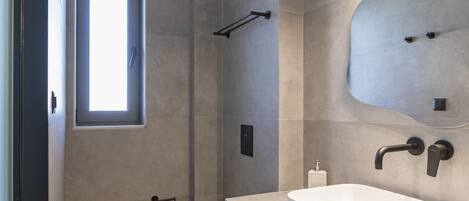 Un baño moderno con un espejo grande, dos lavabos y un inodoro.