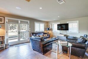A spacious living room with a fireplace, a large window, and a flat-screen TV. - Napa Valley Estate 2 Mi to St Helena (St. Helena)