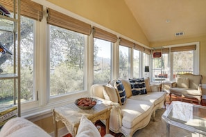 A sunroom with large windows, a sofa, a table, and a chair. - Napa Valley Estate 2 Mi to St Helena (St. Helena)
