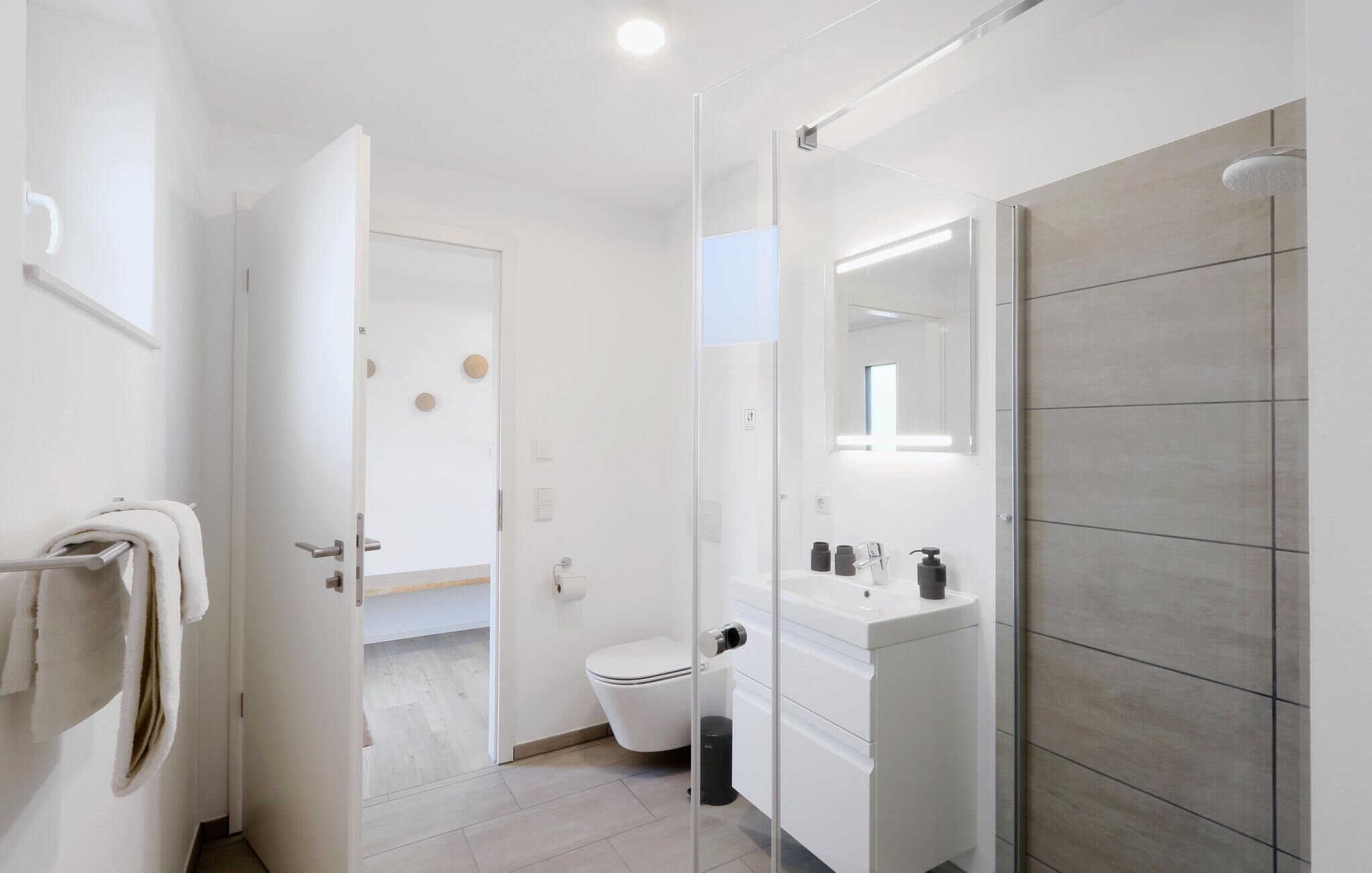 Ein modernes Badezimmer mit Toilette, Waschbecken und Duschbereich.