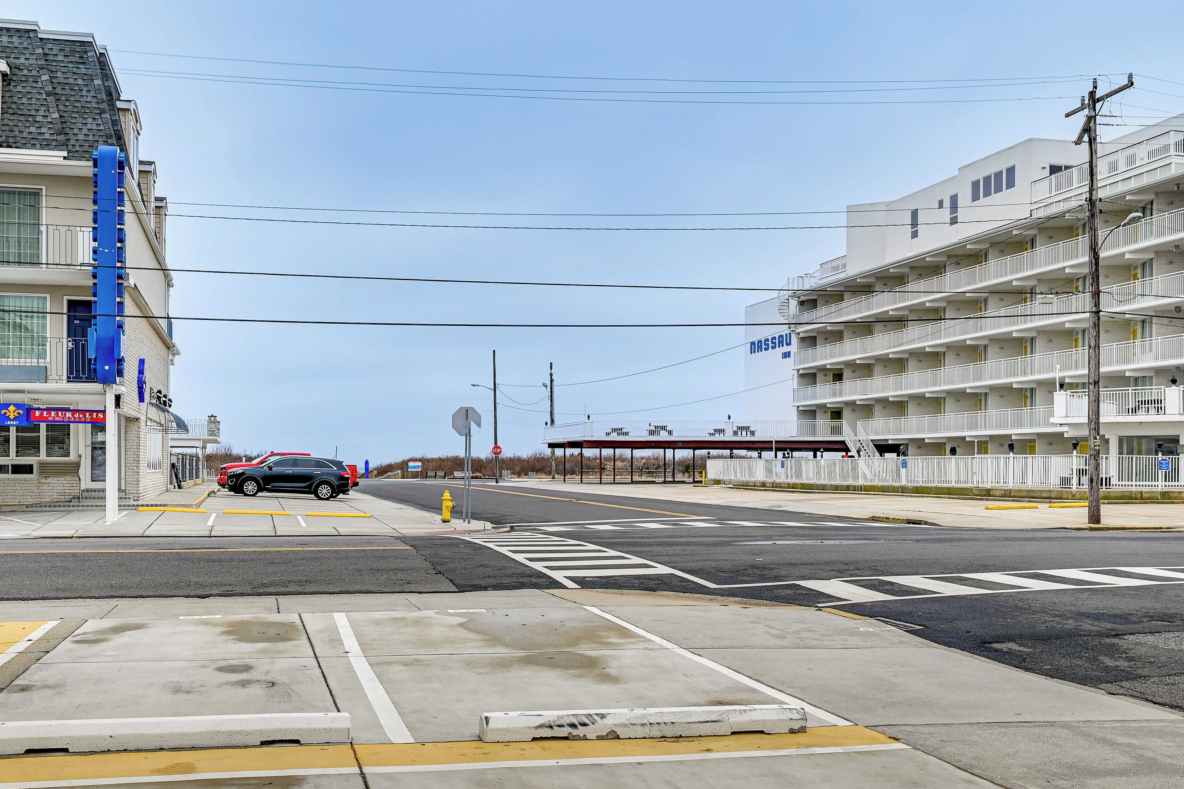 Une vue de rue avec un bâtiment sur lequel on peut voir une enseigne indiquant « NASSAU » et un parking.