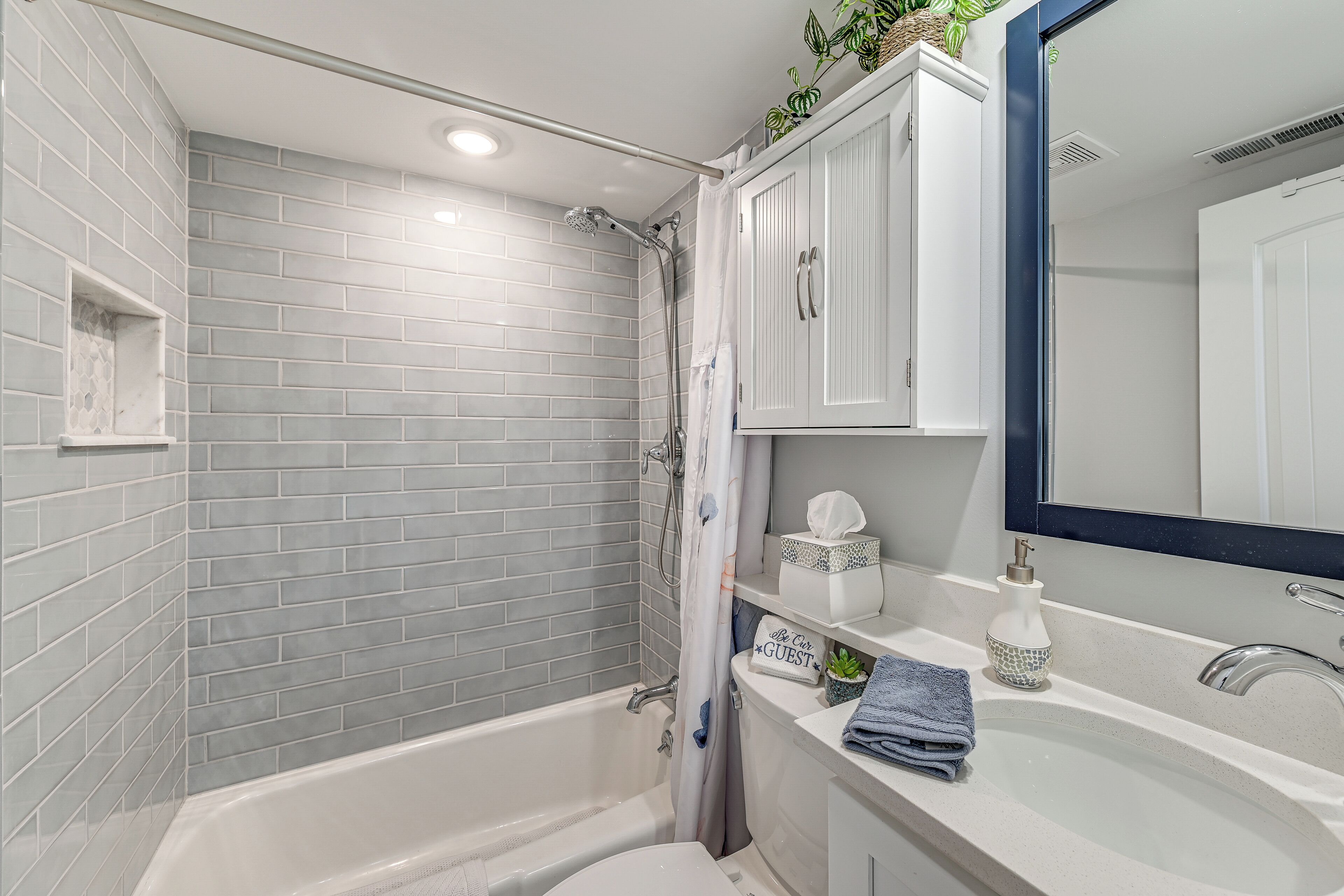 A modern bathroom with a bathtub, a shower, and a sink with a mirror.