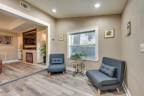 A living room with two grey sofas, a small table with a plant, and a fireplace. - 2 Mi to Shore: Modern Daytona Beach Gem w/ Patio! (Daytona Beach)