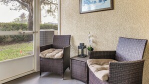 A room with wicker furniture, a small table, and a framed picture on the wall. - 5 Mi to Wdw! Spacious Resort Escape w/ Pool Access (Kissimmee)