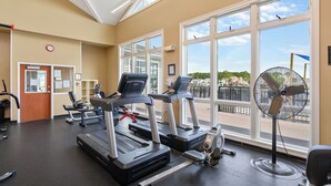 A gym with treadmills, weight machines, and a fan. - Deck & EV Charger: Coastal Retreat 1 Mi to Marina (Greenbackville)