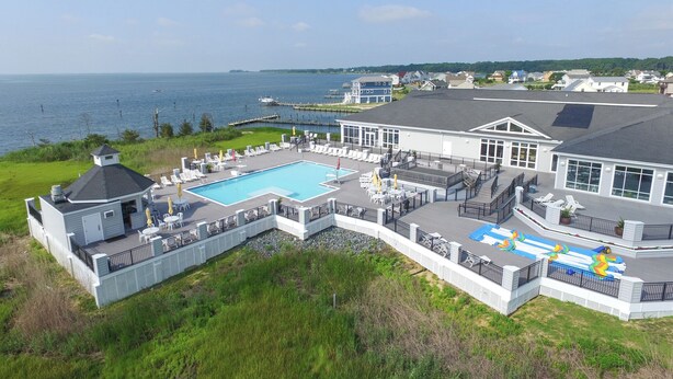A large house with a swimming pool, outdoor seating, and a view of the sea. - Deck & EV Charger: Coastal Retreat 1 Mi to Marina (Greenbackville)