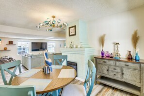 A dining area with a wooden table, blue chairs, and a chandelier. - < 1 Mi to Ramp! Boater's Retreat in Edgewater (Edgewater)