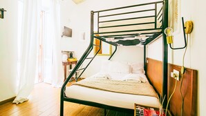 Ein Etagenbett mit Holz-Kopfteil, ein Nachttisch und ein Fenster mit Vorhängen.