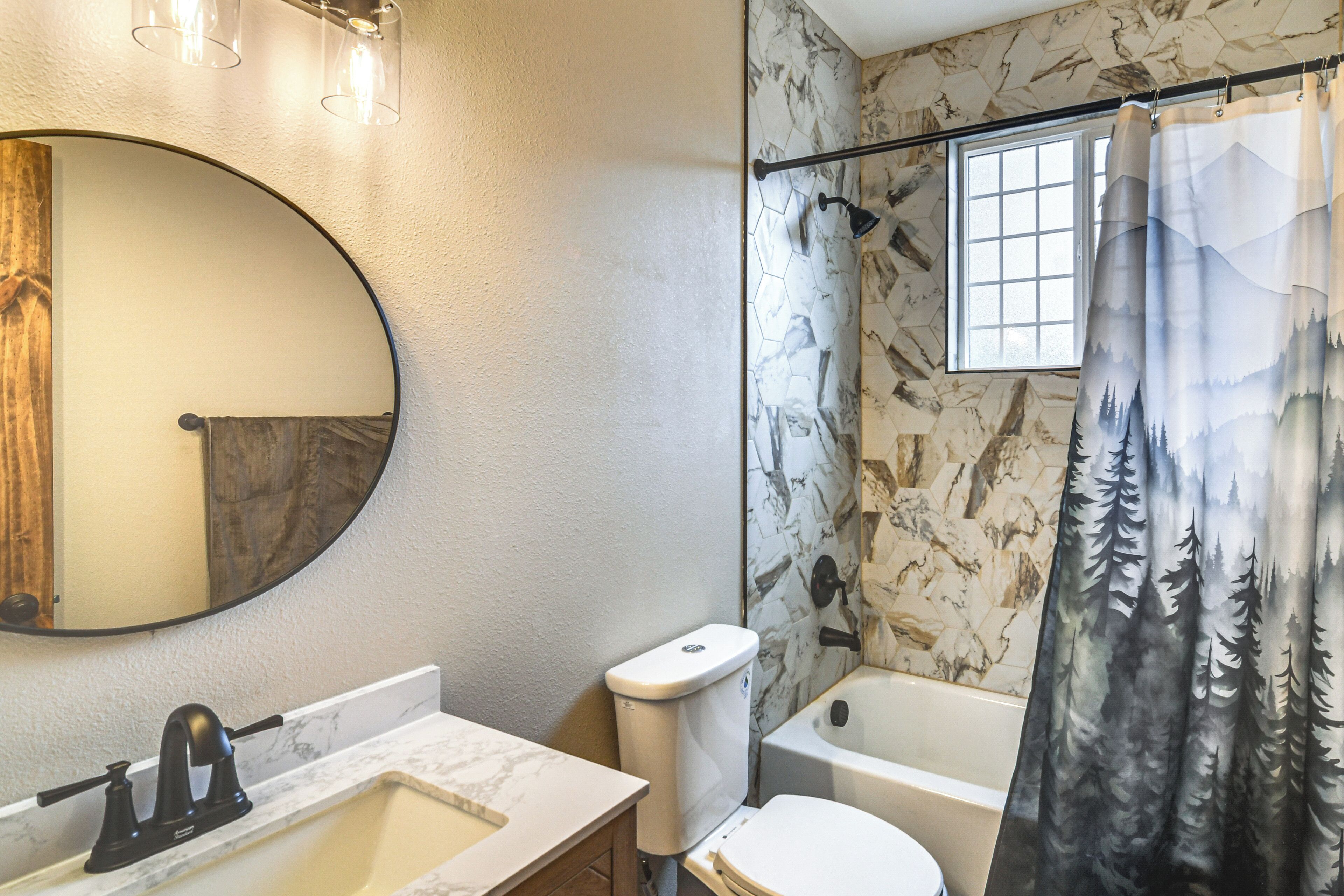 A bathroom with a marble sink, toilet, and bathtub.