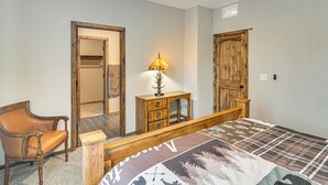 Ein Schlafzimmer mit einem hölzernen Bettgestell, einem Sessel, einer Kommode und einem Spiegel.