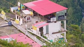 A red-roofed building with a sign indicating a restaurant. - Sarvaheet (Ukhimath)