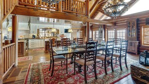 A spacious dining area with a high wooden ceiling, a chandelier, and a large dining table surrounded by chairs. - Theater, Gym, Hot Tub: Versailles 'heritage Lodge' (Versailles)
