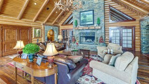 A spacious living room with a fireplace, leather sofas, and a high wooden ceiling. - Theater, Gym, Hot Tub: Versailles 'heritage Lodge' (Versailles)