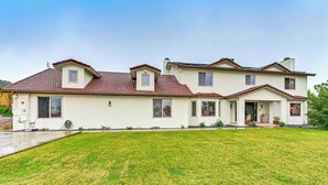 A two-story house with a red-tiled roof, a front porch, and a well-maintained lawn. - Game Room, Hot Tub & Views! Luxe Temecula Estate (Temecula)