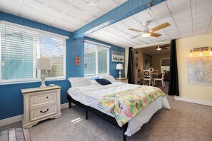 A bedroom with a bed, nightstands, a ceiling fan, and a map on the wall. - Heated Pool & Boat Dock! Port Charlotte Getaway (Port Charlotte)