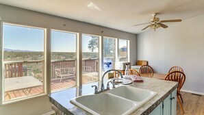 A kitchen with a large window, a sink, and a ceiling fan. - Hualapai Mountain Views & Deck! Yucca Getaway (Yucca)