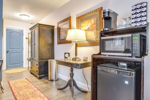 A compact kitchen with a microwave, coffee maker, and refrigerator.