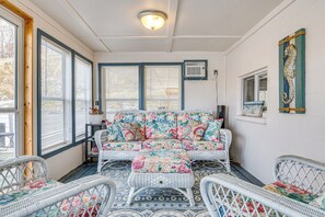 A cozy room with a wicker sofa and chairs, a patterned rug, and a decorative seahorse wall art.
