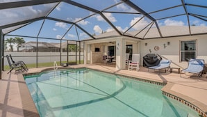 Una piscina techada al aire libre con sillas de descanso y un área de patio.