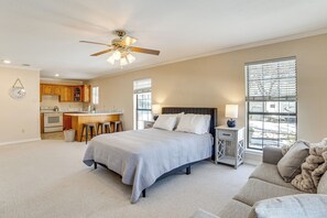A spacious bedroom with a large bed, a nightstand, a sofa, and a view of the kitchen. - 'texoma Shores Hideaway' Family Home w/ Water View (Pottsboro)