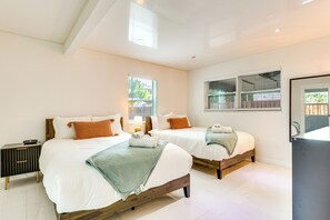 A bedroom with two beds, a bedside table, and a window. - 3 Mi to Sea! Family Pool House in Fort Lauderdale (Fort Lauderdale)