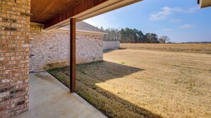 Un patio abrité, doté d’un mur en briques et d’un sol en béton.