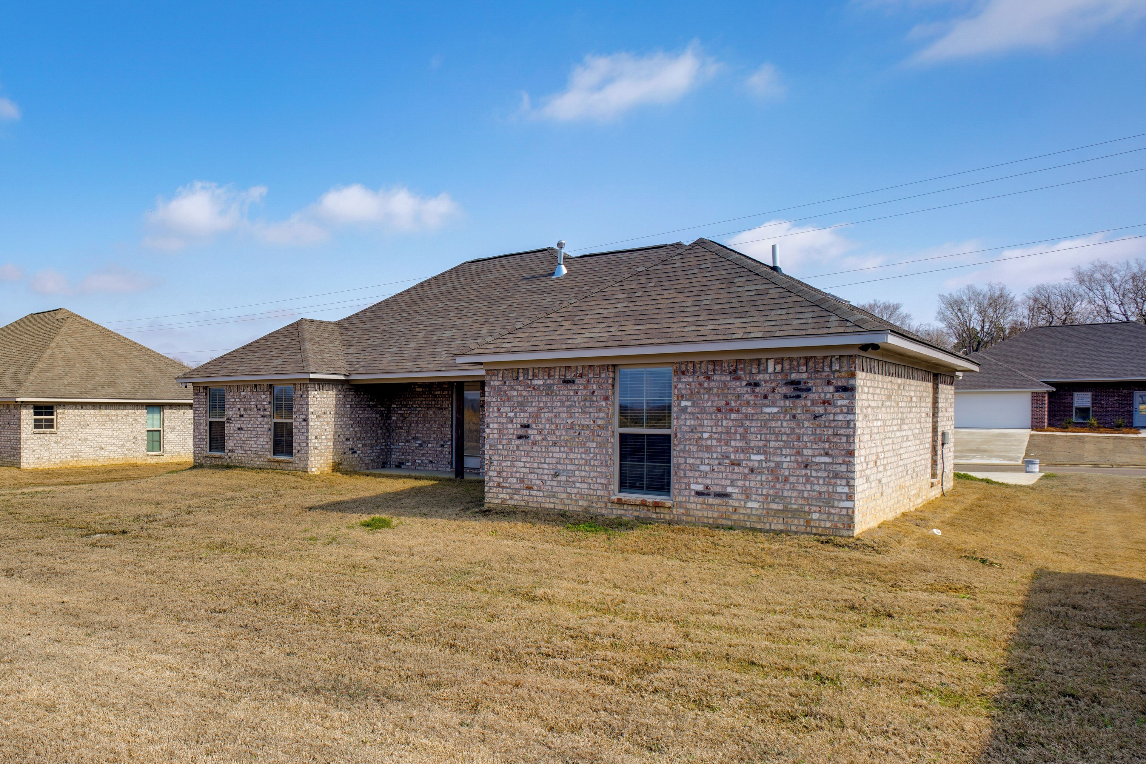 A two-story brick house with a flat roof, a front porch, and a garage.