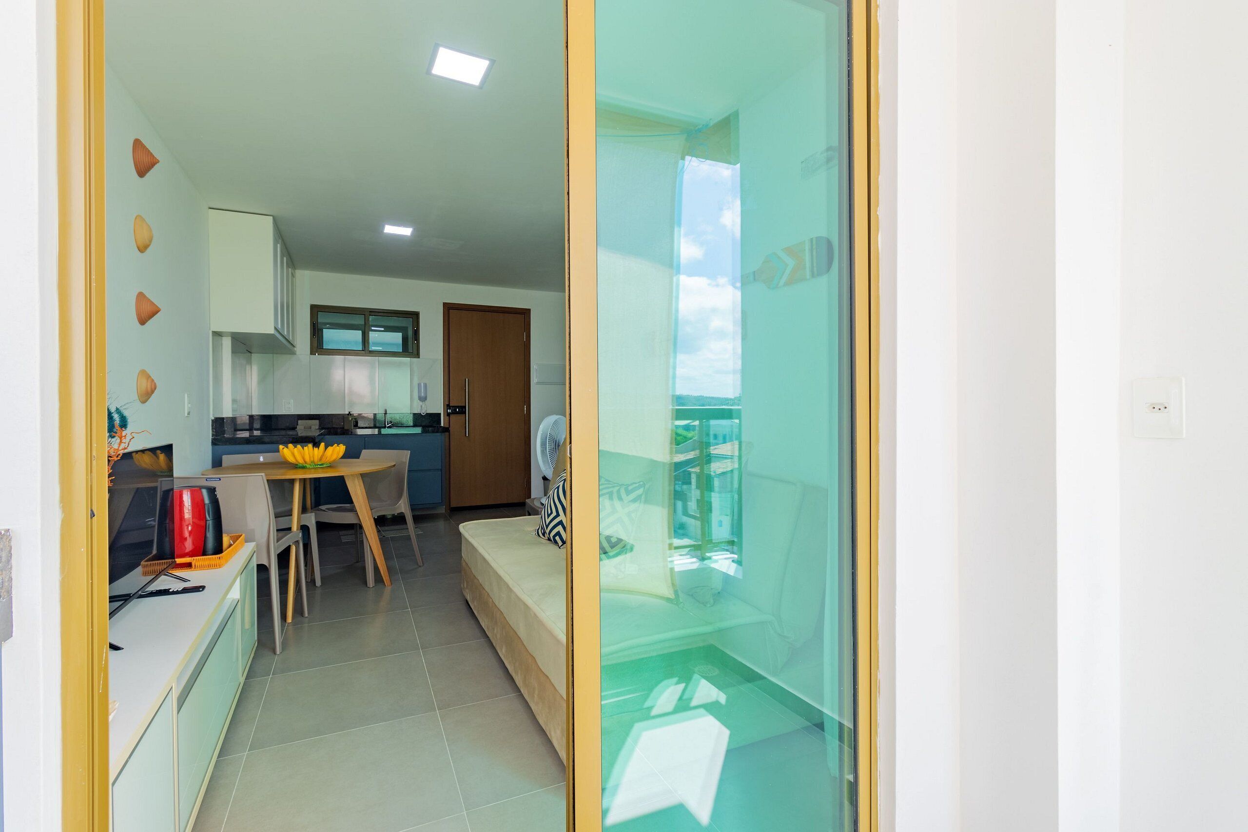 Una cocina moderna con comedor, sofá y un separador de vidrio.