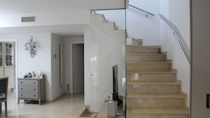Ein modernes Interieur mit Treppe, Flachbildfernseher und minimalistischer Einrichtung.
