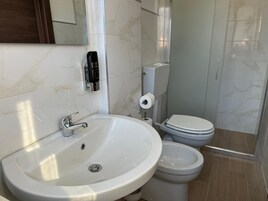 Un baño con lavamanos blanco, inodoro y bidé.