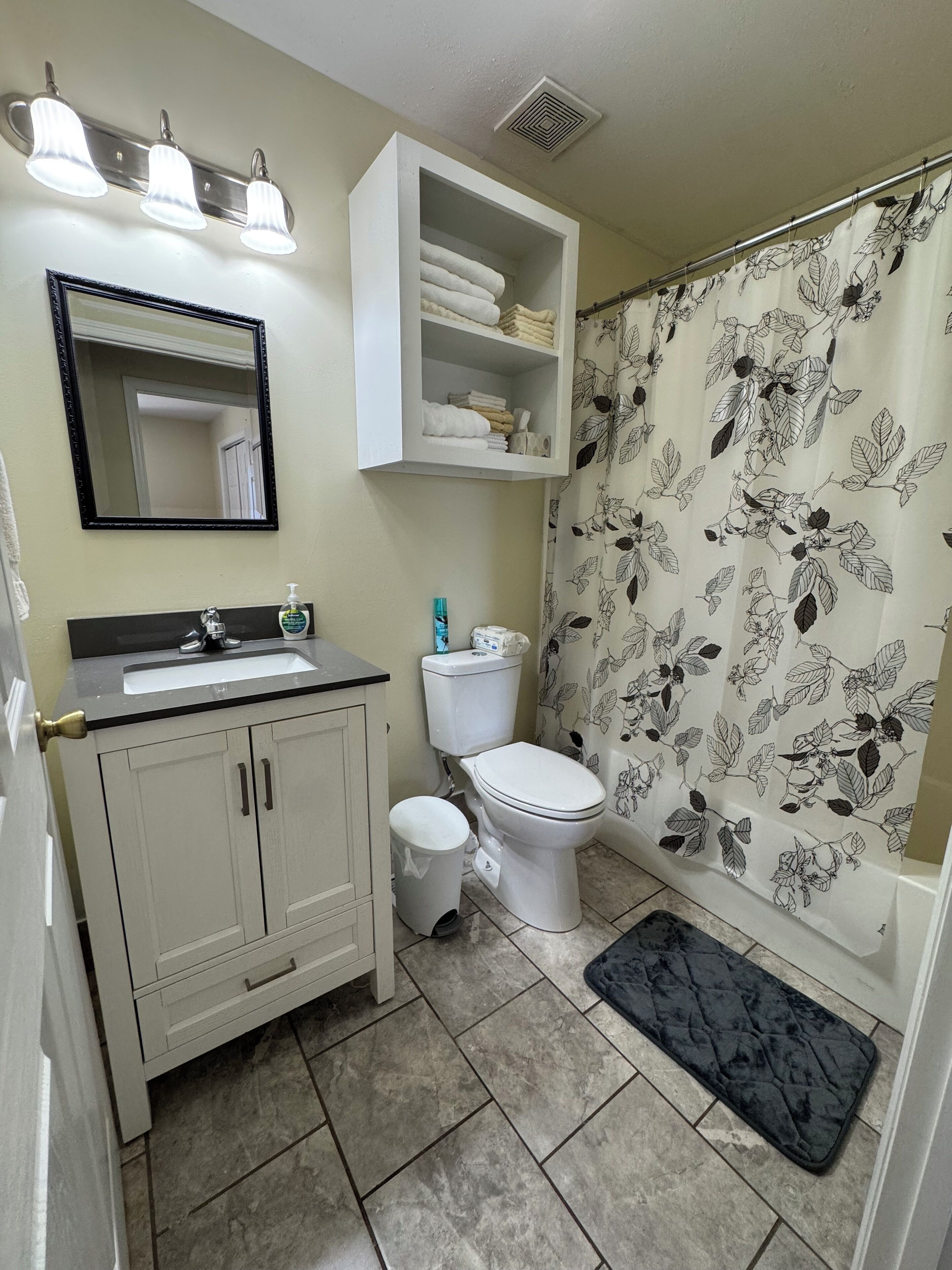 A bathroom with a sink, toilet, and shower curtain.