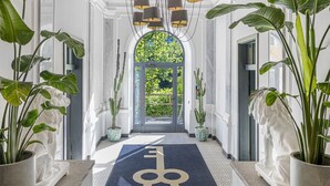 A hallway with a black carpet, a key-shaped rug, and a chandelier. - Spacious XXL Deluxe suite with private balcony and village views. (Bad Gastein)