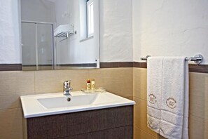 A bathroom with a white sink, dark wooden cabinet, and a towel rack with a white towel. - Outeiro do Barro  (Reguengos de Monsaraz)