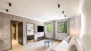 Un salon moderne avec un canapé, une table basse, un téléviseur et une cheminée.