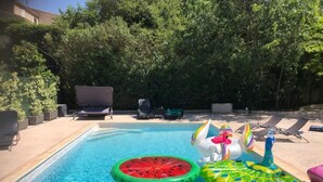A swimming pool with inflatable toys, lounge chairs, and a hedge in the background. - Ideal for vacations with family or friends: semi-detached house 150 m². (Mougins)