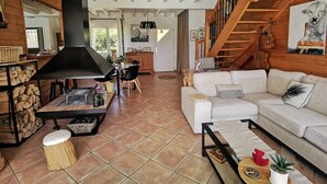 Un vaste espace de vie doté d’une cheminée, de planchers en bois, d’un canapé blanc et d’un escalier.